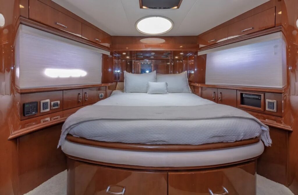 Luxury yacht master bedroom with circular bed and polished wooden interior finishes
