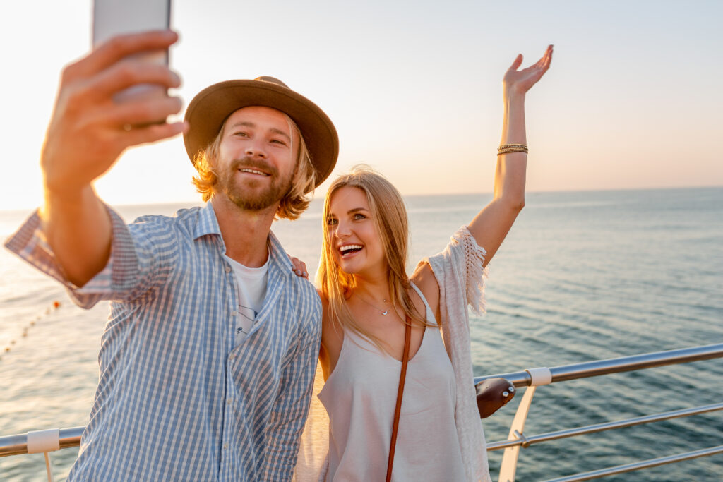 Happy couple celebrating on yacht deck with ocean view background