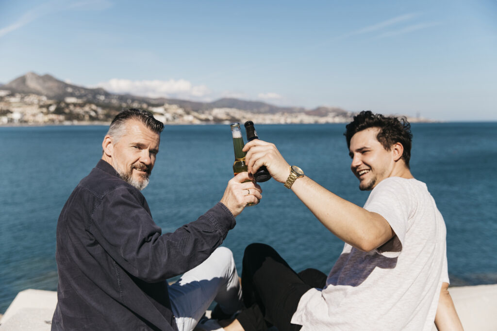Friends celebrating with drinks on yacht deck overlooking ocean horizon