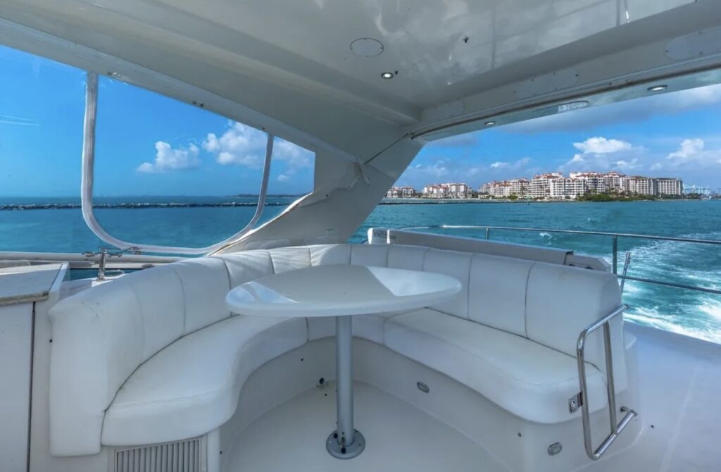 Bright yacht interior lounge with wraparound seating and ocean city views