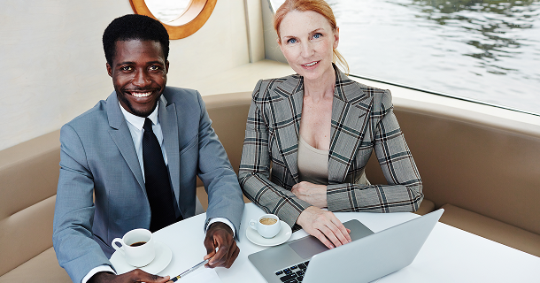 Professional business partners smiling and working together on laptop